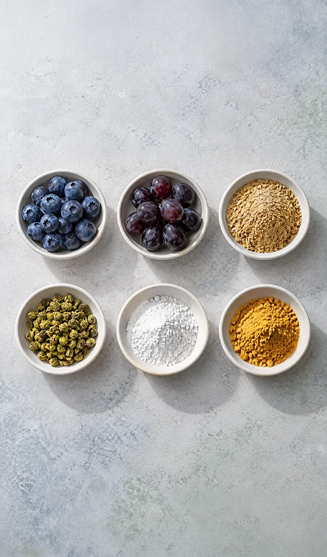 The Lujevit active formula Six bowls of Lujevit active ingredients on a light stone surface